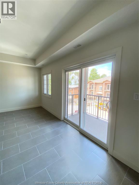 A room with a sliding glass door leading to a balcony.