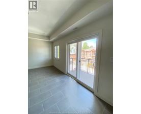 A room with a sliding glass door leading to a balcony.