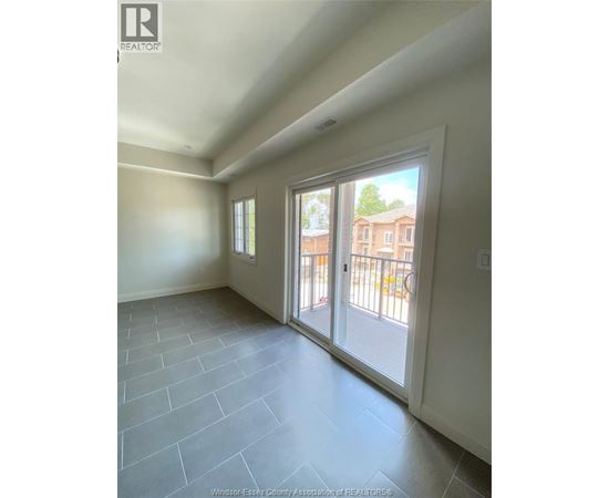 A room with a sliding glass door leading to a balcony.