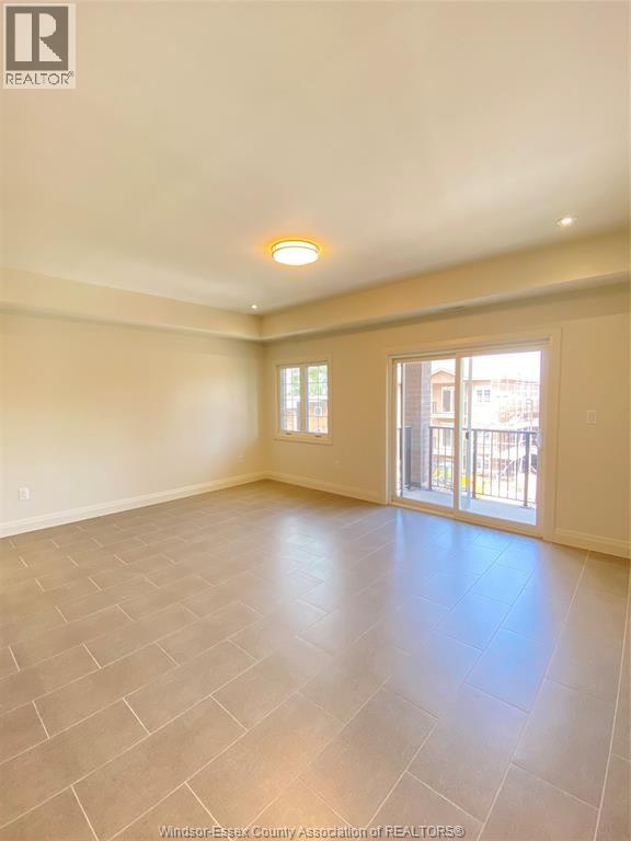 A spacious room with tile flooring and a large window.