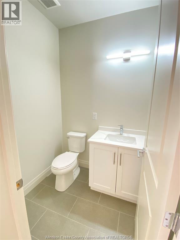 A white toilet and sink in a small bathroom.