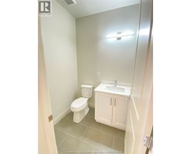 A white toilet and sink in a small bathroom.