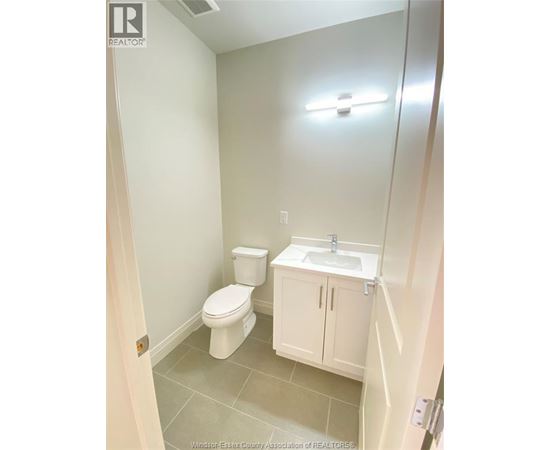 A white toilet and sink in a small bathroom.