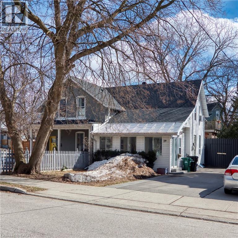 A house with a white picket fence and a tree in front.