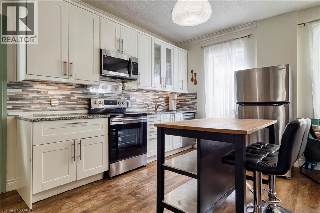 A kitchen with a wooden table and black chairs.