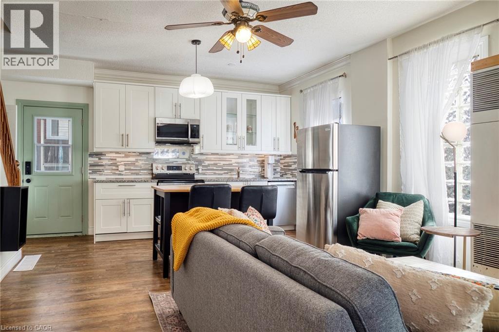 A living room with a grey couch and a ceiling fan.