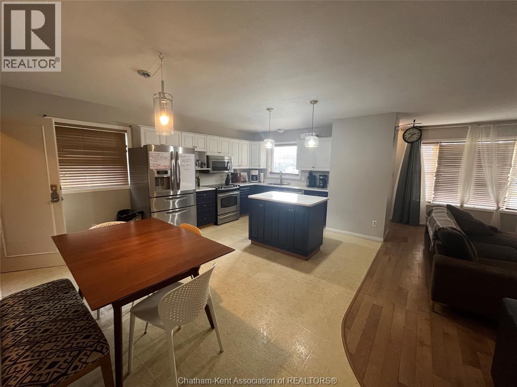 A well-lit kitchen and dining area with a wooden table and chairs.