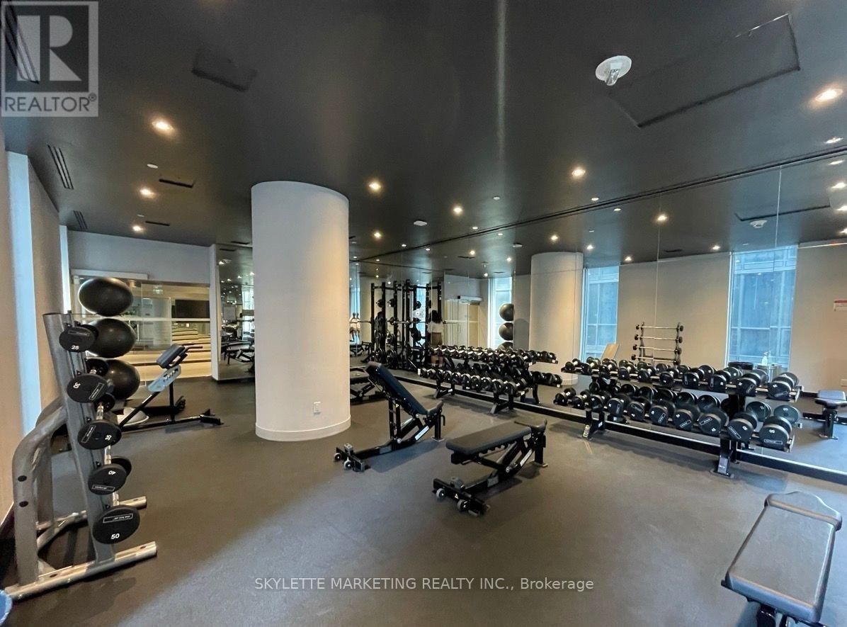 A gym with a variety of equipment including weights and benches.
