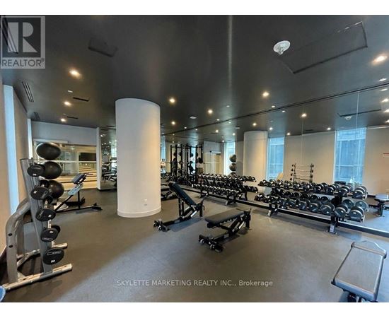 A gym with a variety of equipment including weights and benches.