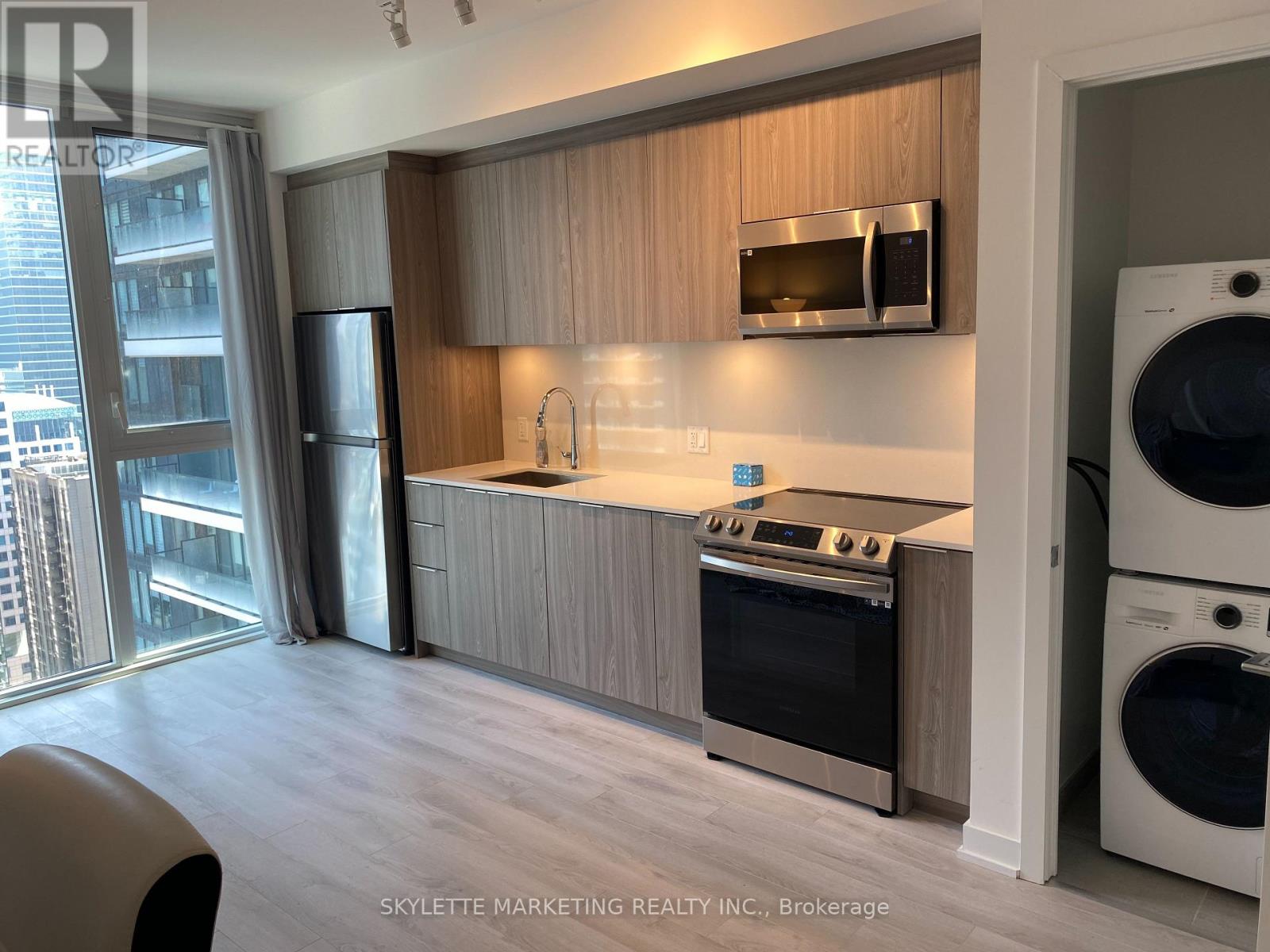 A modern kitchen with wooden cabinets and stainless steel appliances.