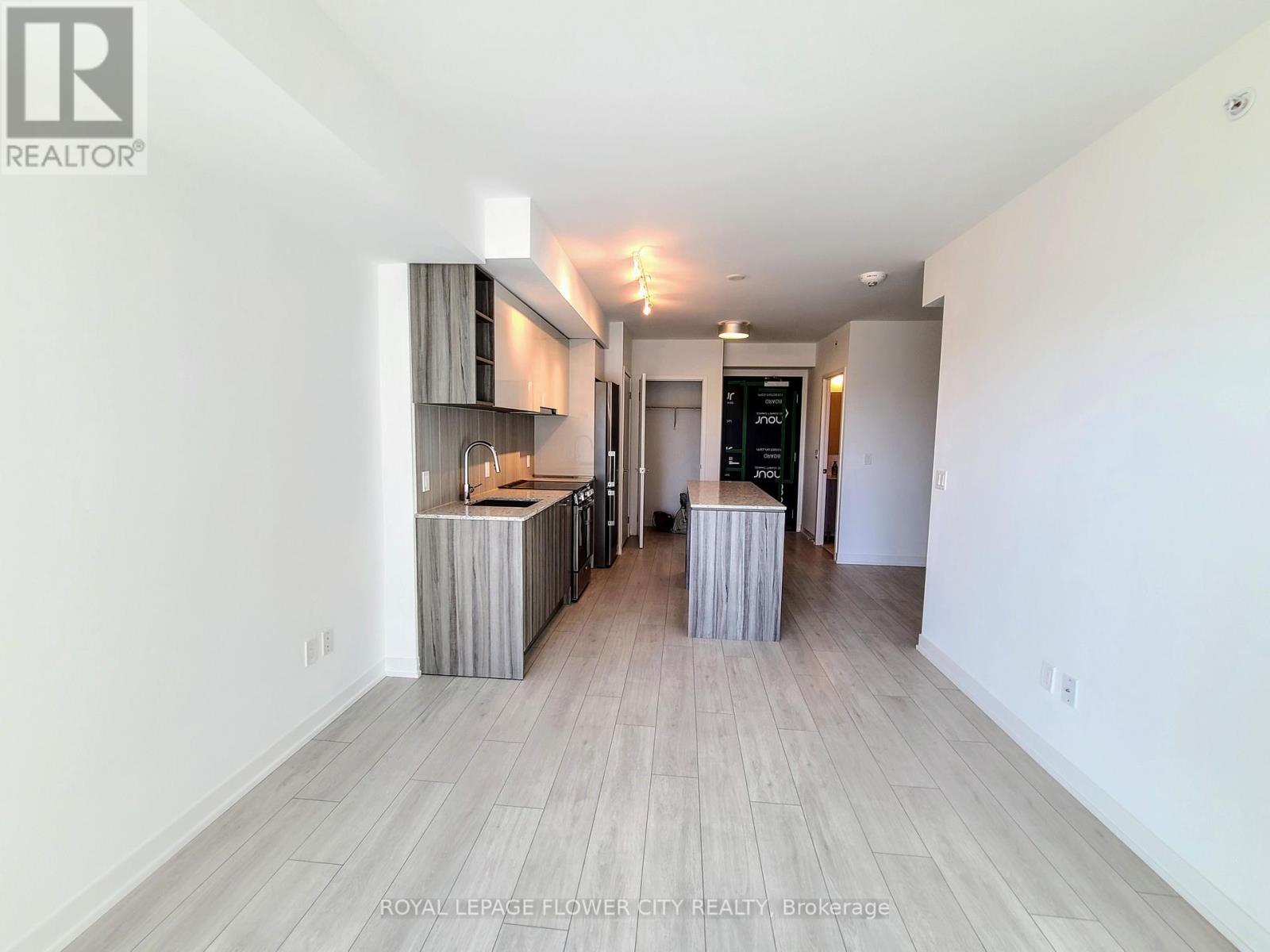 A spacious room with a kitchenette and a dining area.