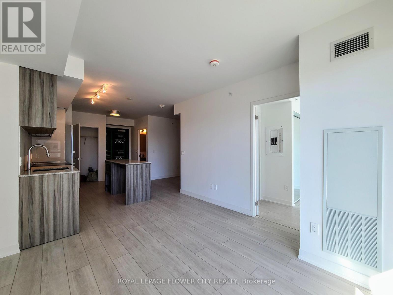 A spacious room with a wooden floor and white walls.