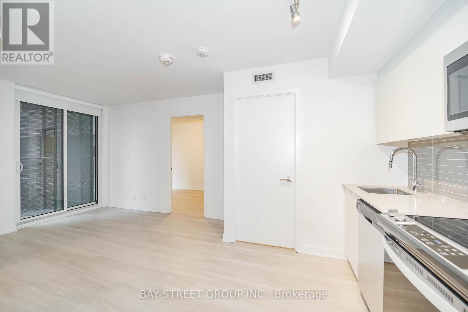 A white kitchen with a sink and a microwave.