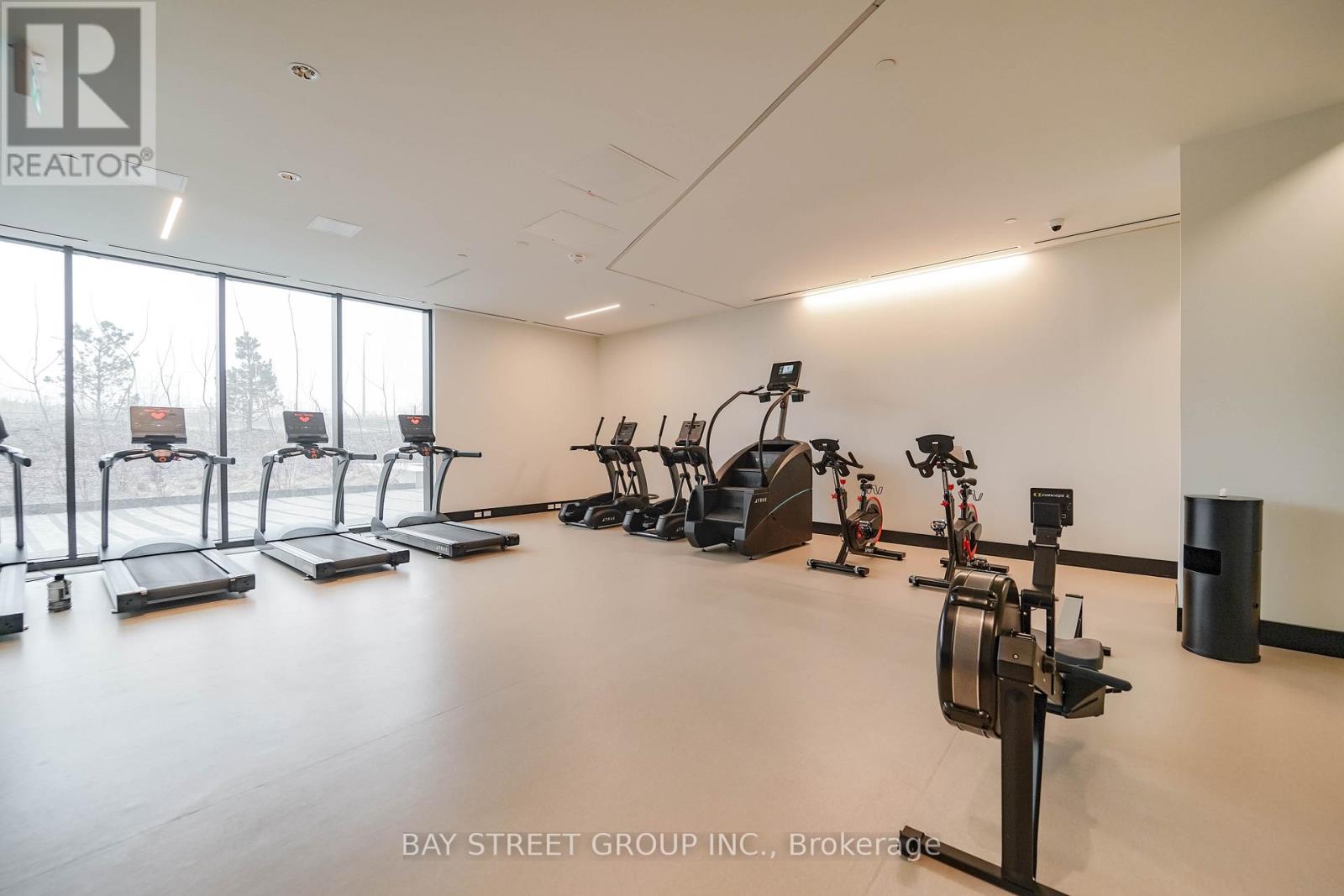 A gym with a variety of exercise equipment including treadmills, stationary bikes, and weight machines.