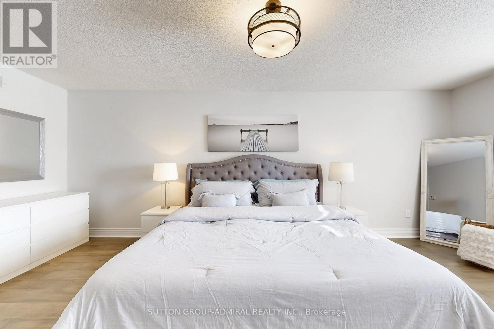 A bedroom with a large bed and a chandelier.