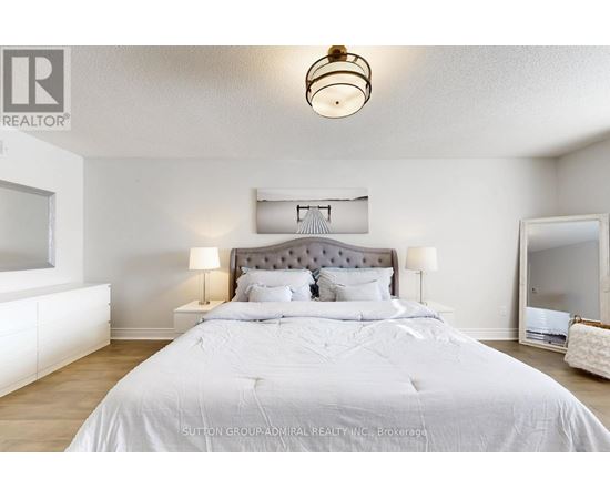 A bedroom with a large bed and a chandelier.
