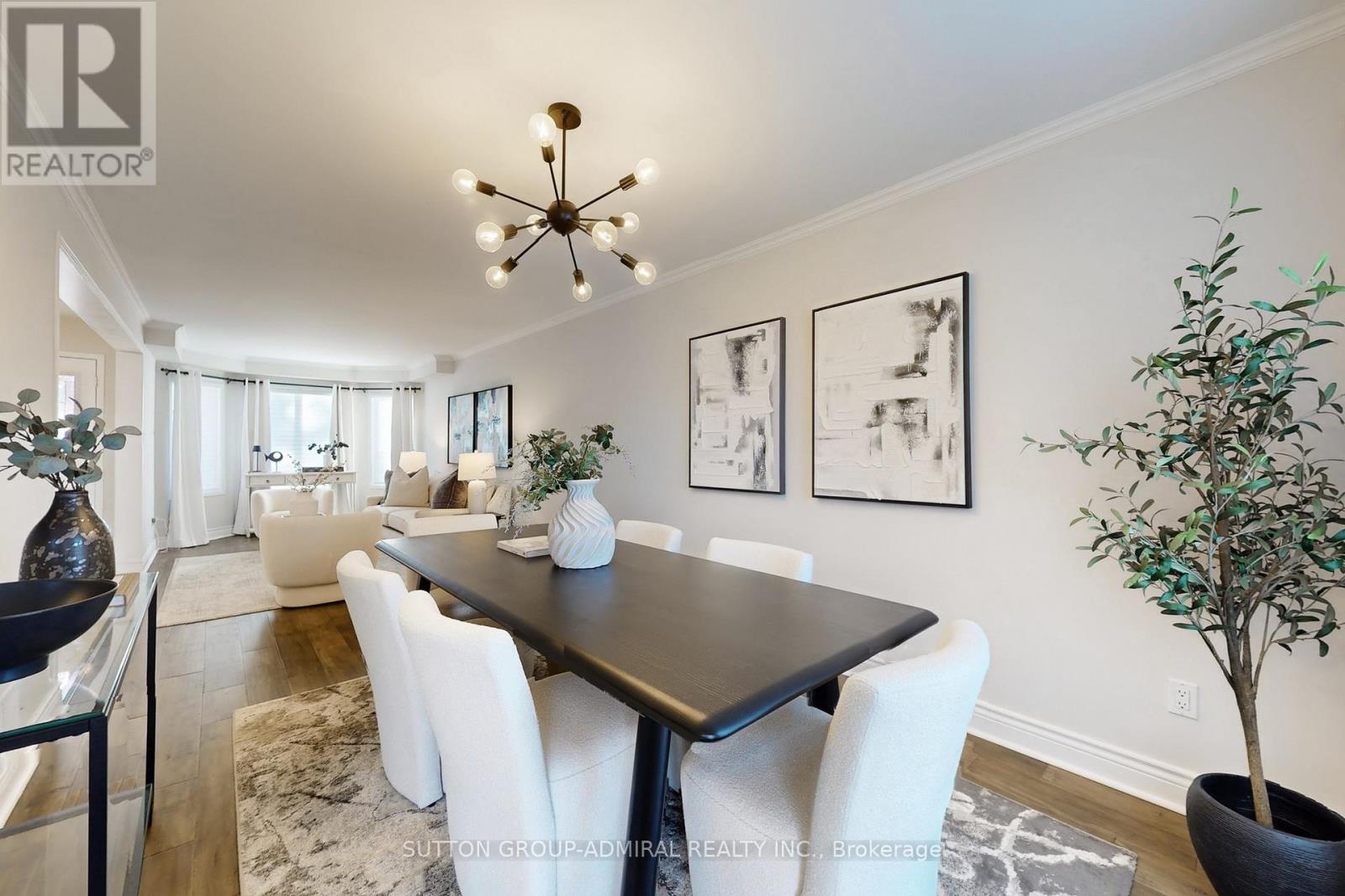 A dining room with a black table and white chairs.
