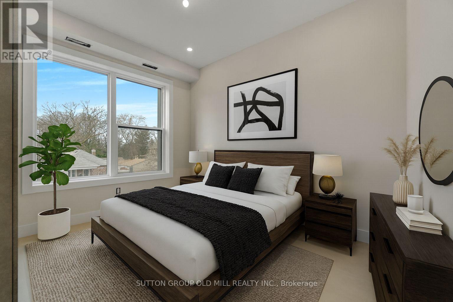 A bedroom with a large bed, a potted plant, and a mirror on the wall.