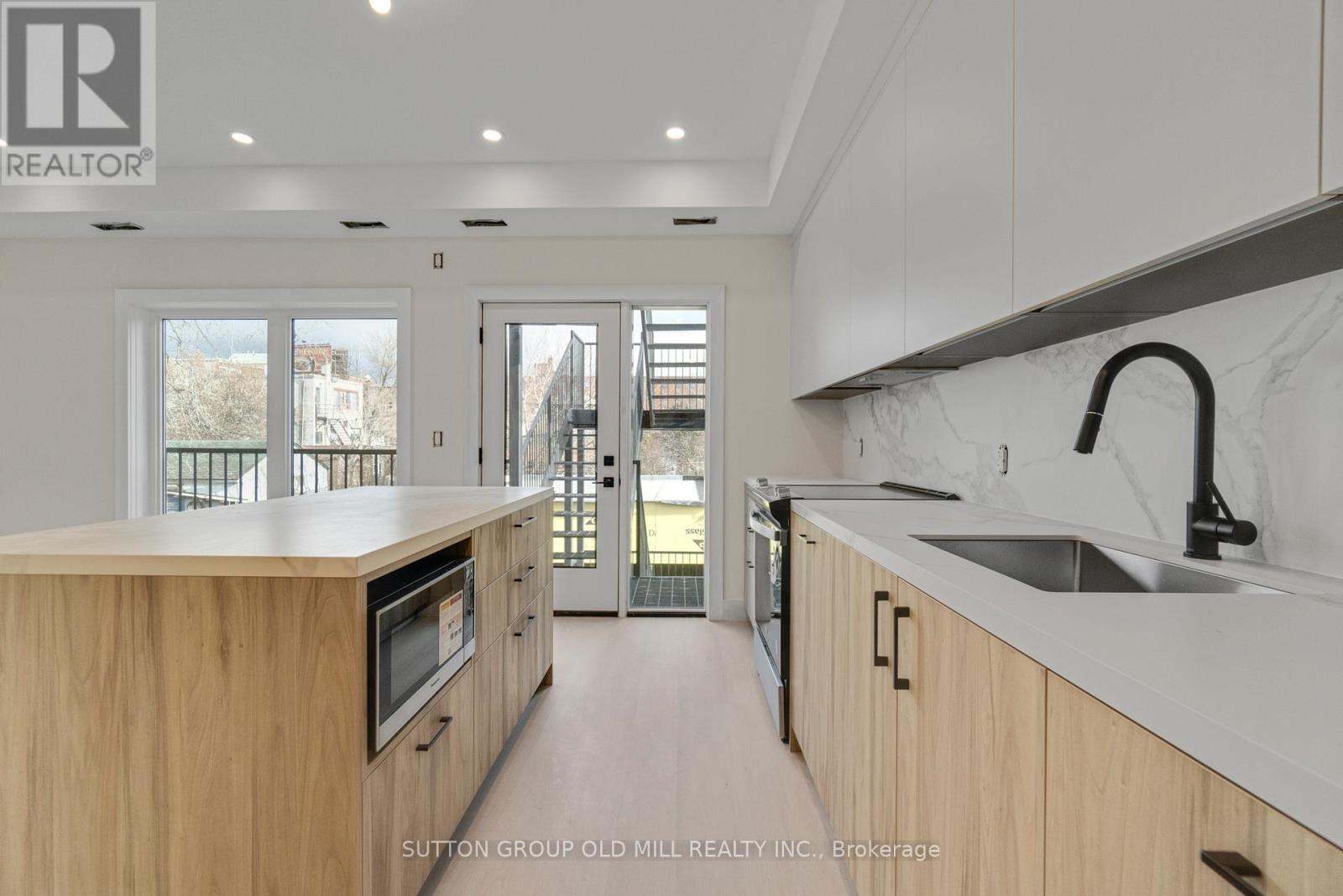 A kitchen with wooden cabinets and a marble countertop.