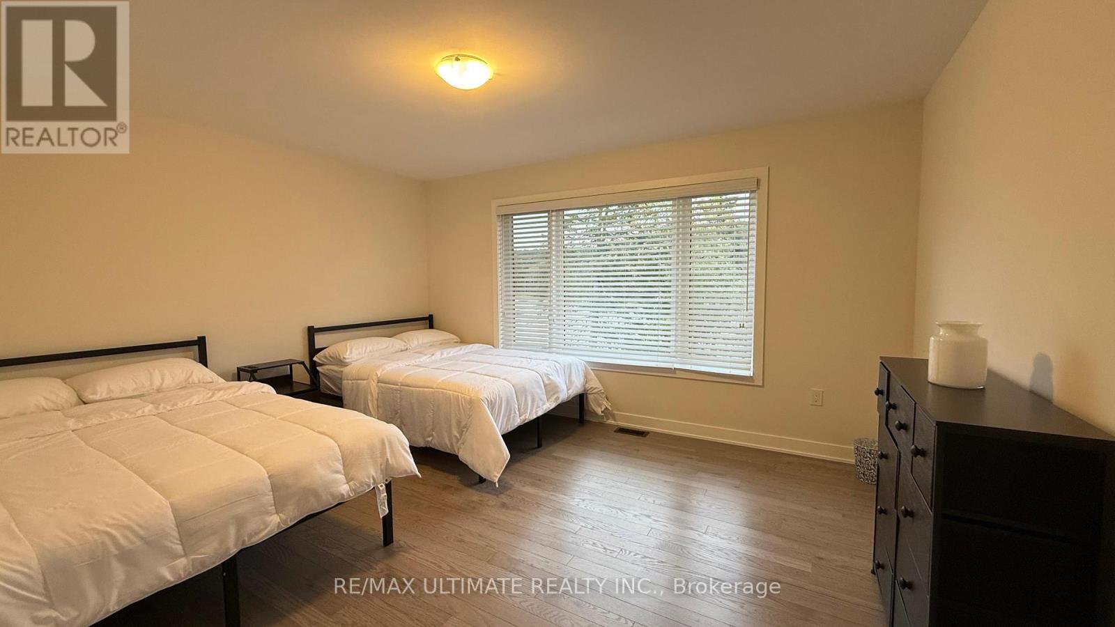 A bedroom with two beds and a dresser.