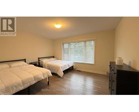 A bedroom with two beds and a dresser.