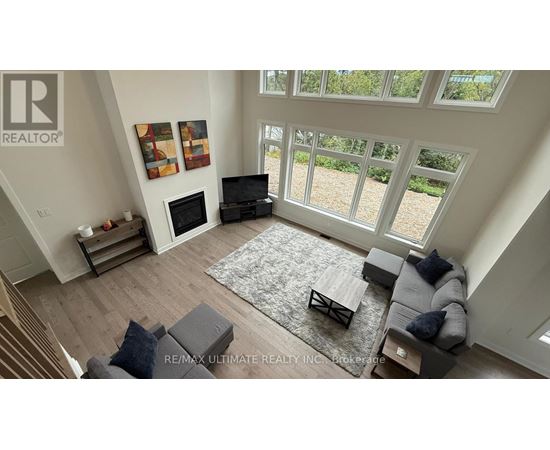 A living room with a grey couch and a rug.