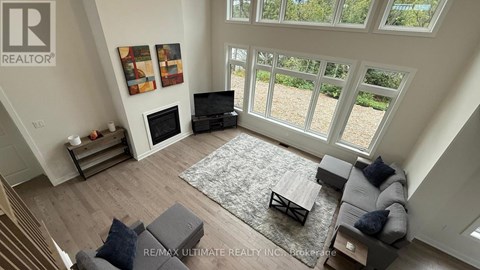 A living room with a grey couch and a rug.