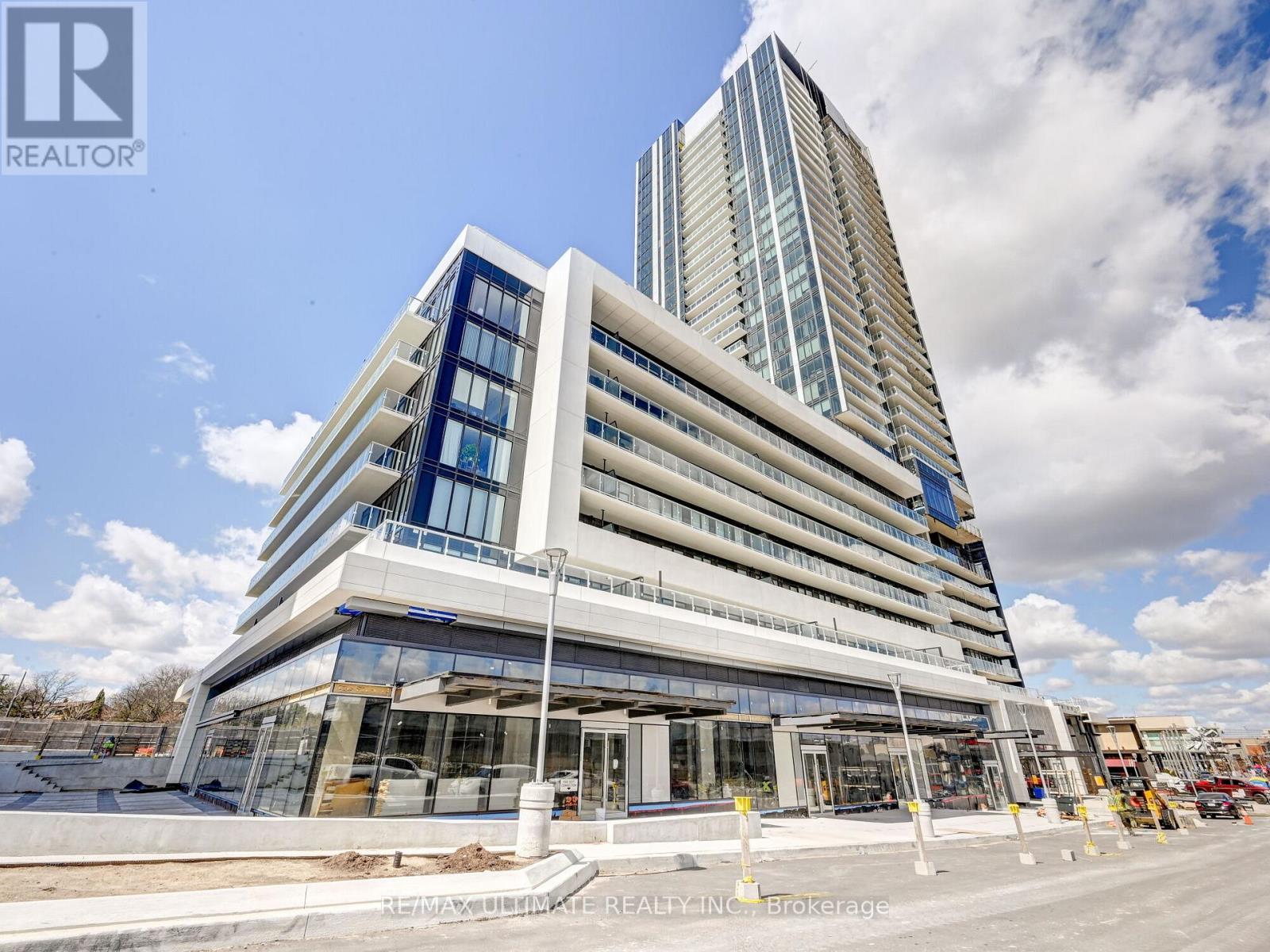 A modern multi-story building with a glass facade is under construction.
