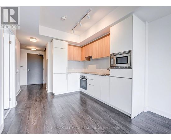 A kitchen with white cabinets and a wooden countertop.