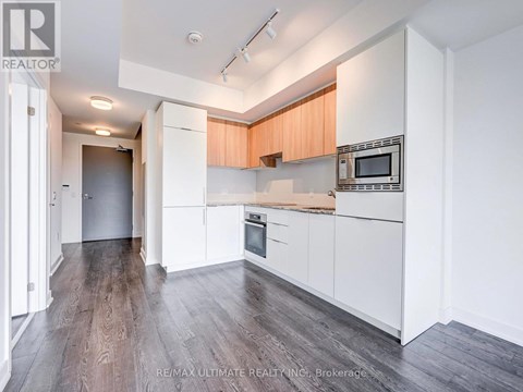 A kitchen with white cabinets and a wooden countertop.
