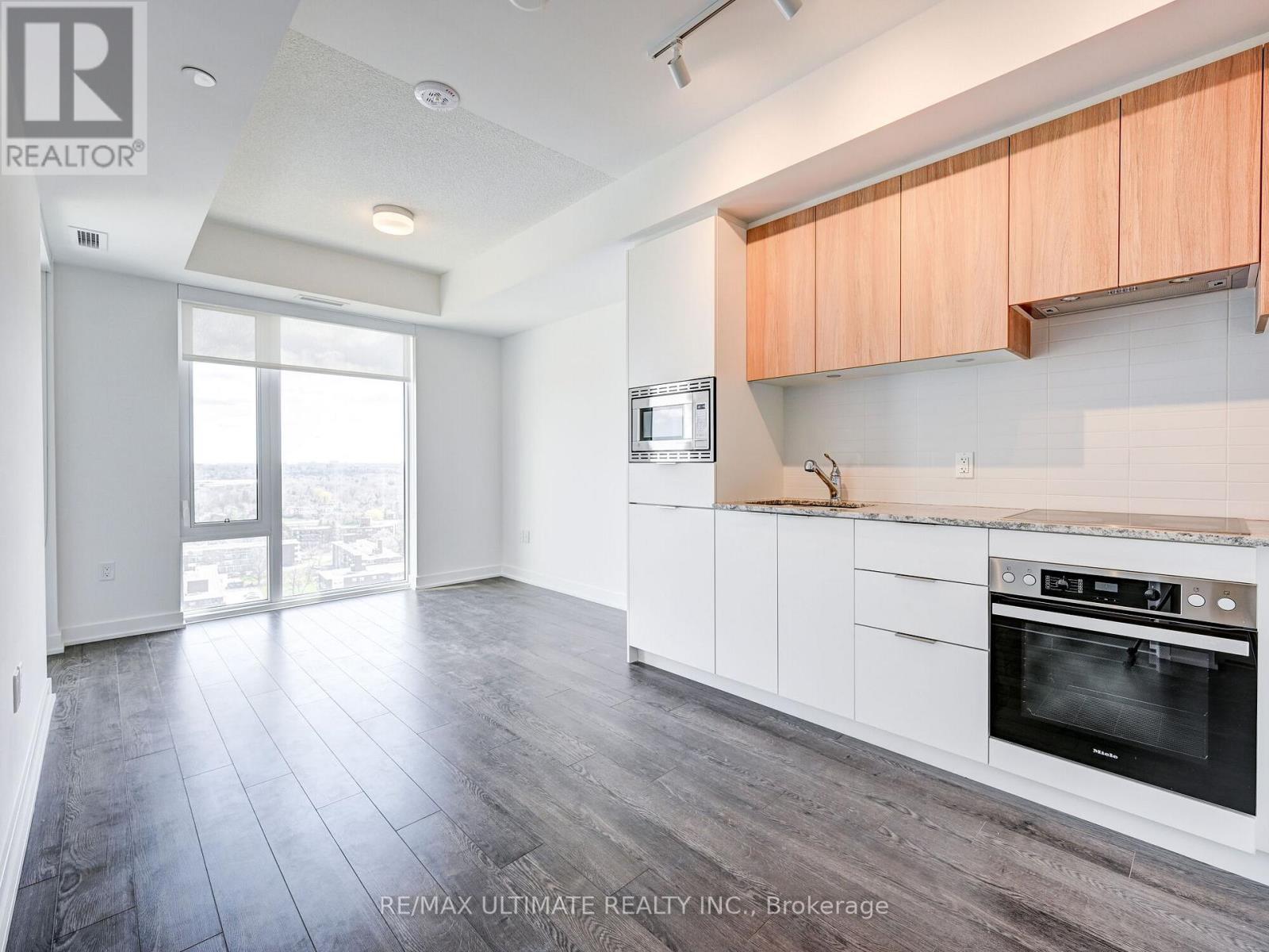 A kitchen with white cabinets and a black oven.