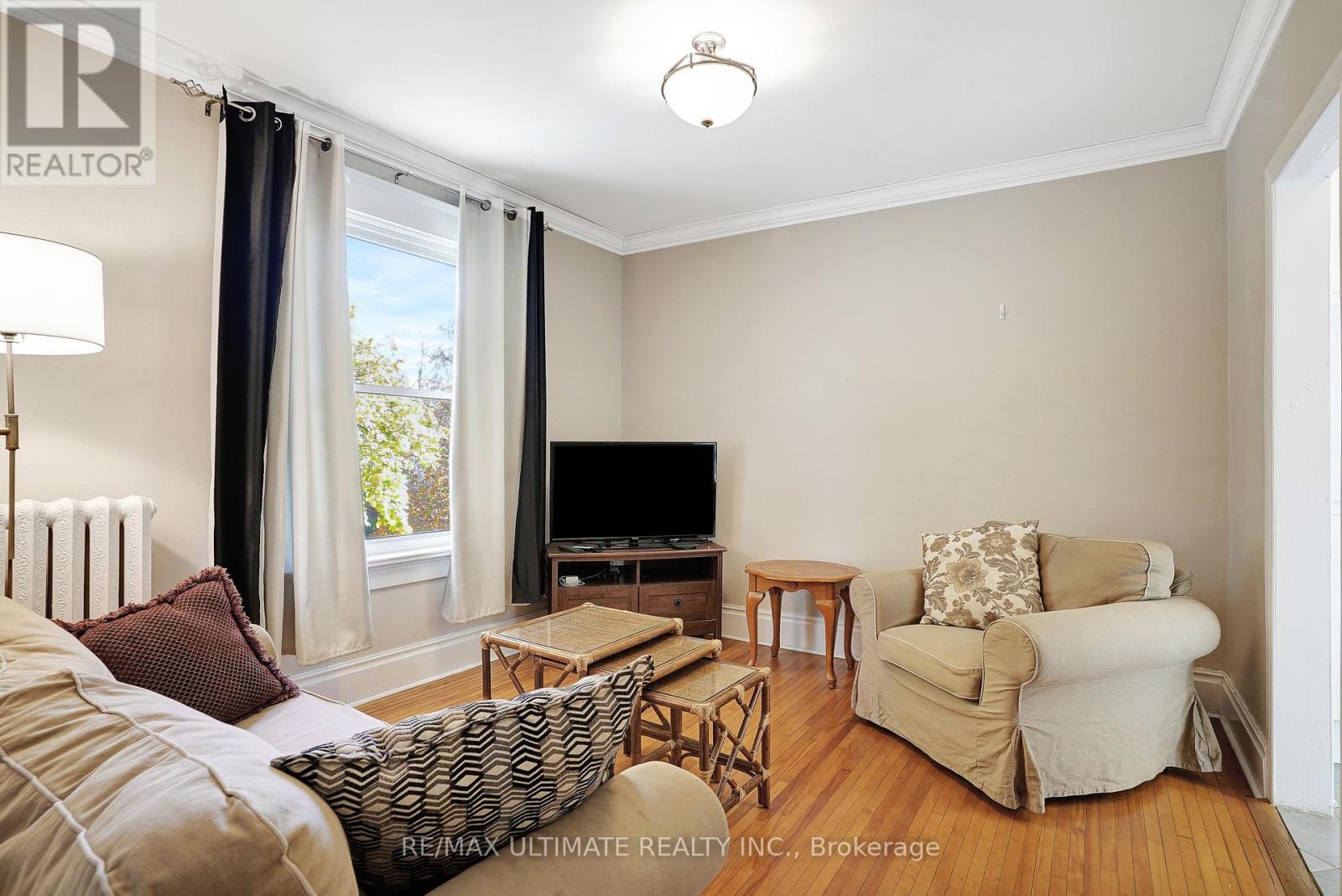 A living room with a couch, chair, and television.