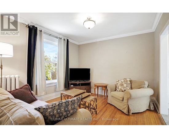 A living room with a couch, chair, and television.