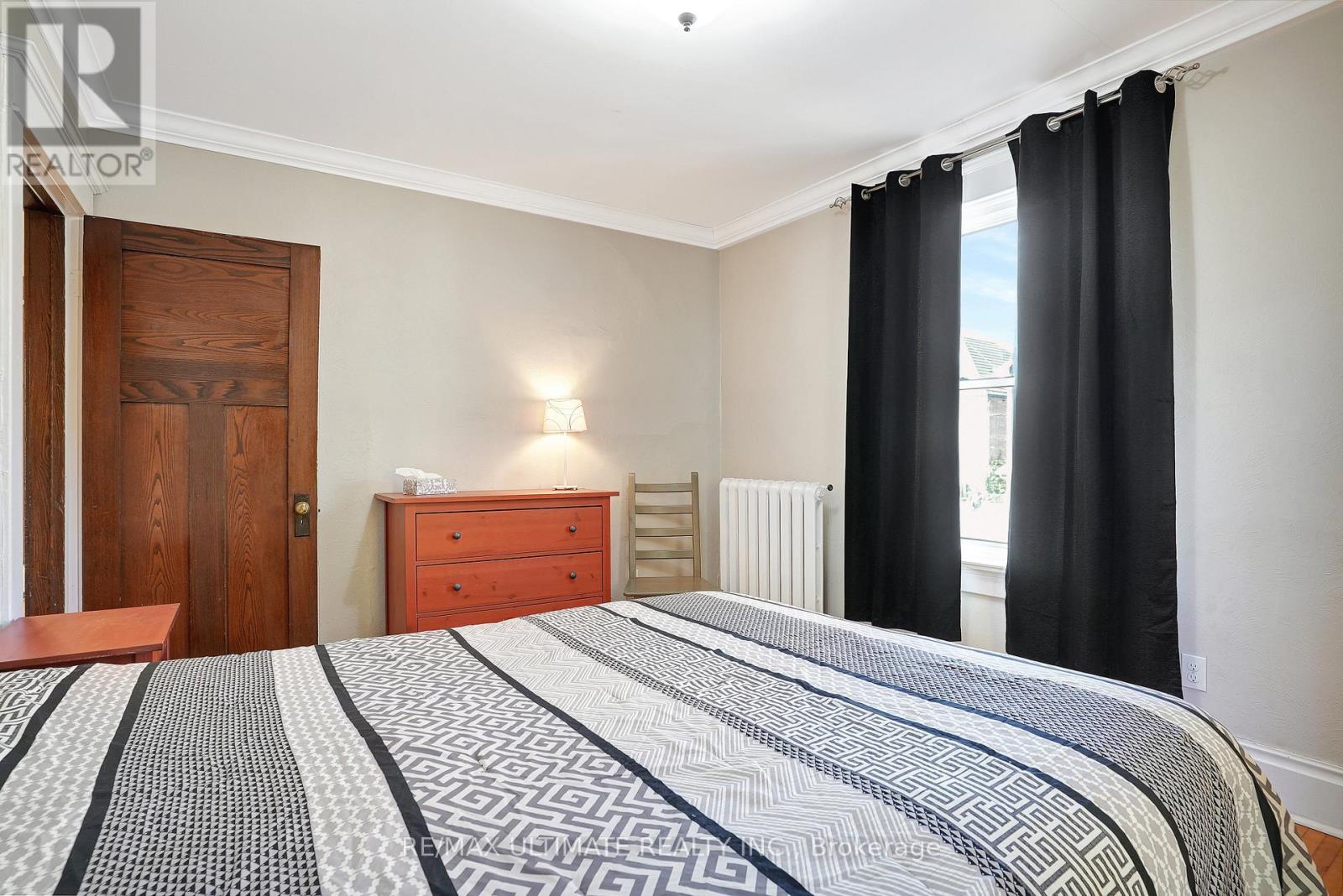 A bedroom with a large bed and a wooden door.