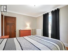 A bedroom with a large bed and a wooden door.