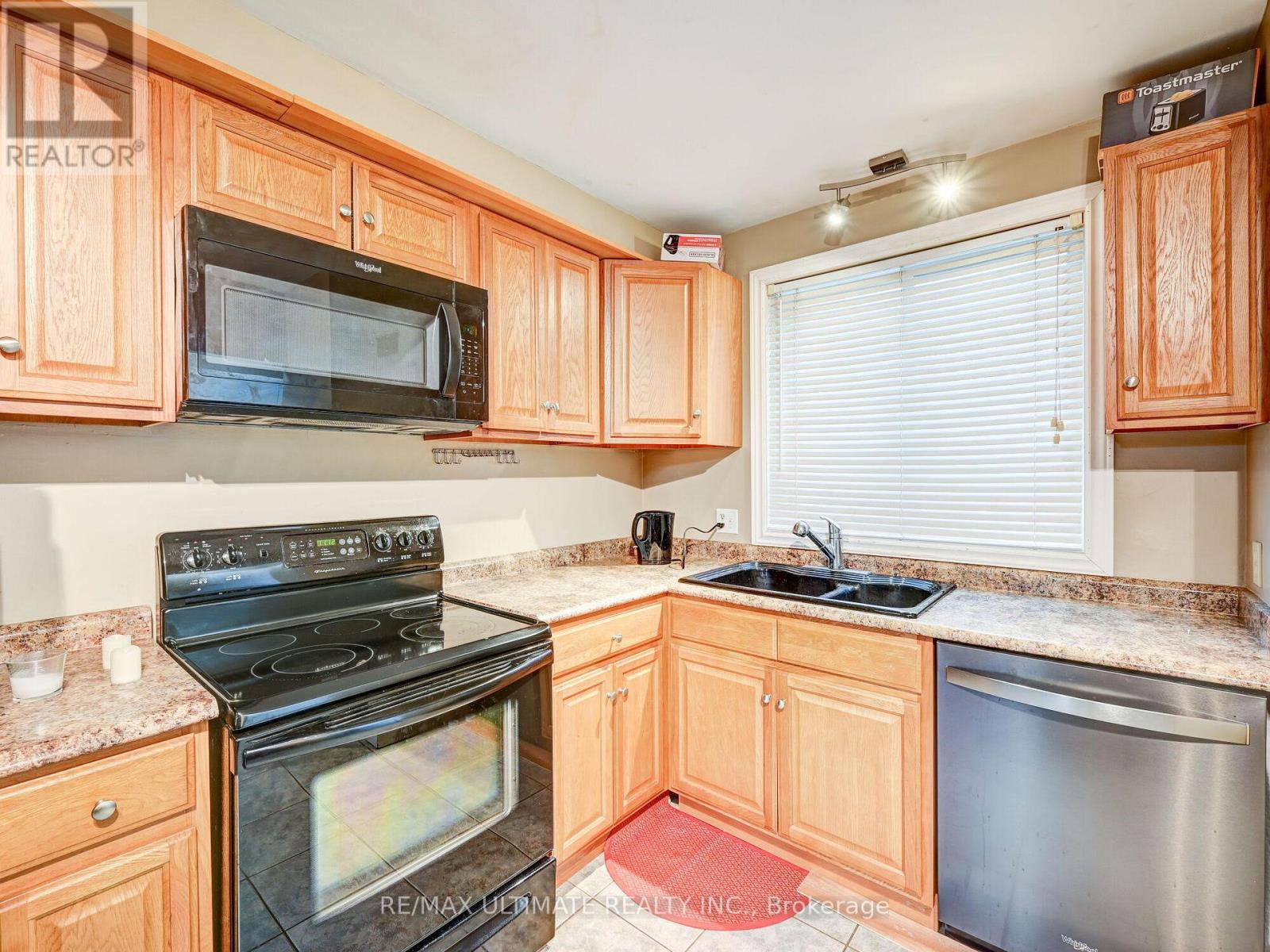 A kitchen with wooden cabinets and a black stove top oven.
