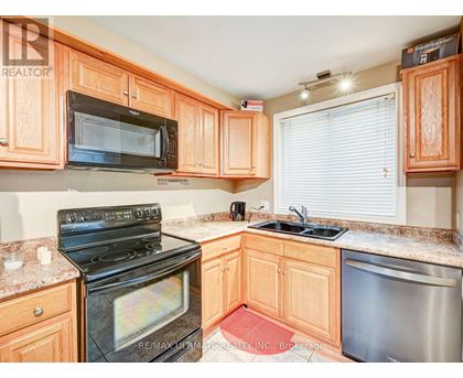 A kitchen with wooden cabinets and a black stove top oven.