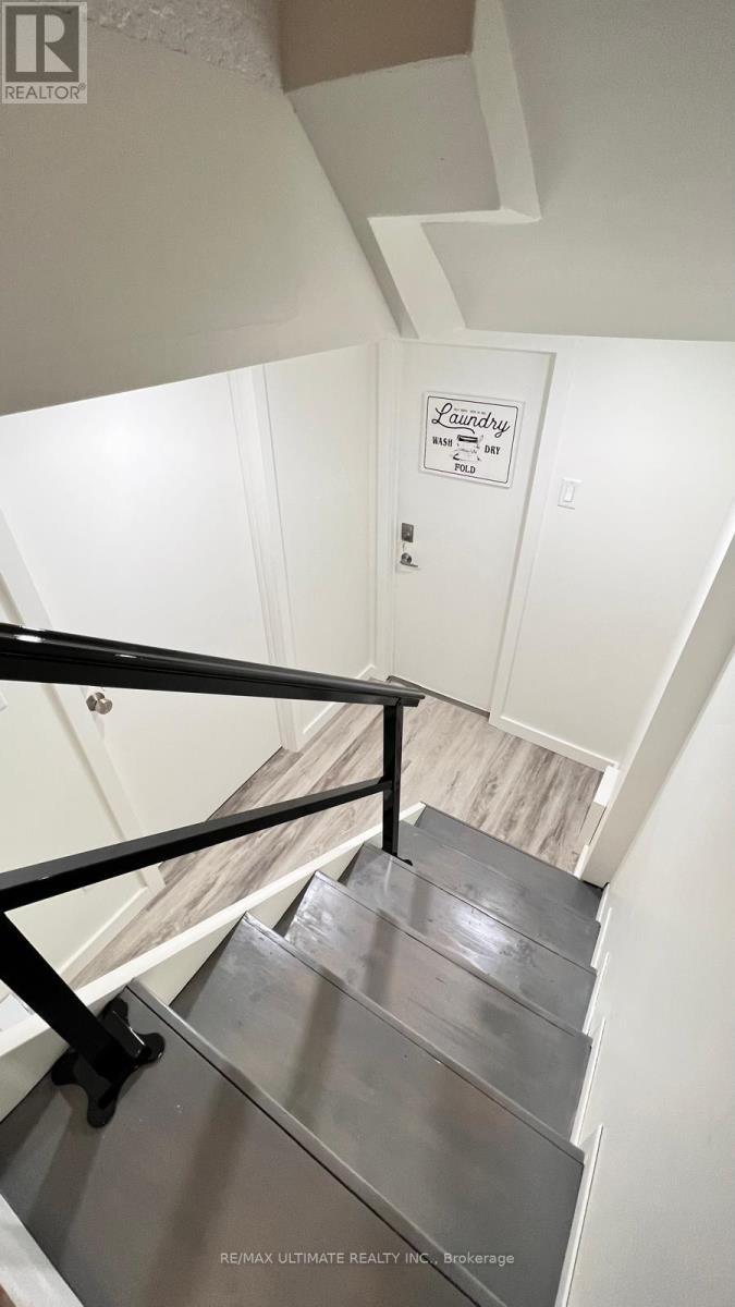 A staircase with a metal railing and a sign that says Laundry.