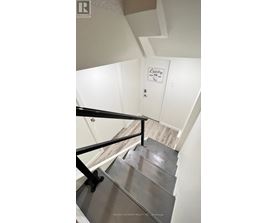 A staircase with a metal railing and a sign that says Laundry.