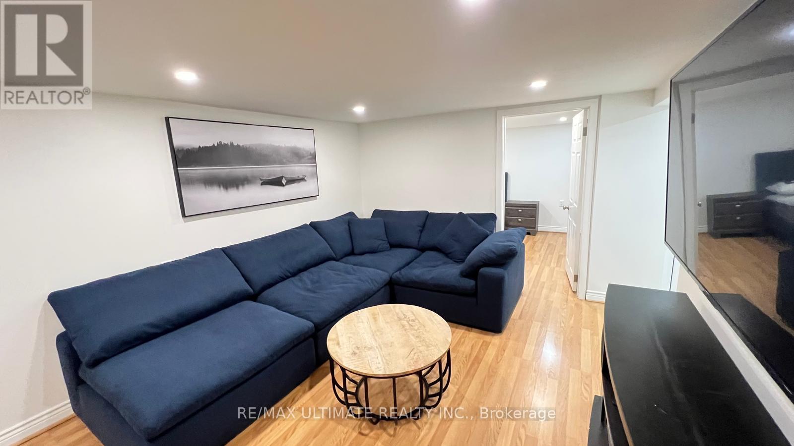 A living room with a blue sectional sofa and a wooden coffee table.