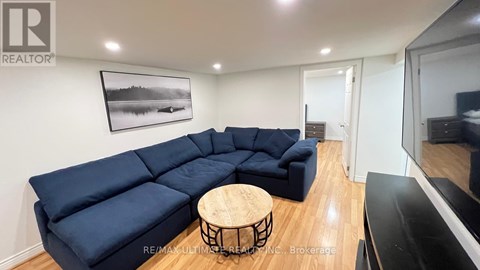 A living room with a blue sectional sofa and a wooden coffee table.