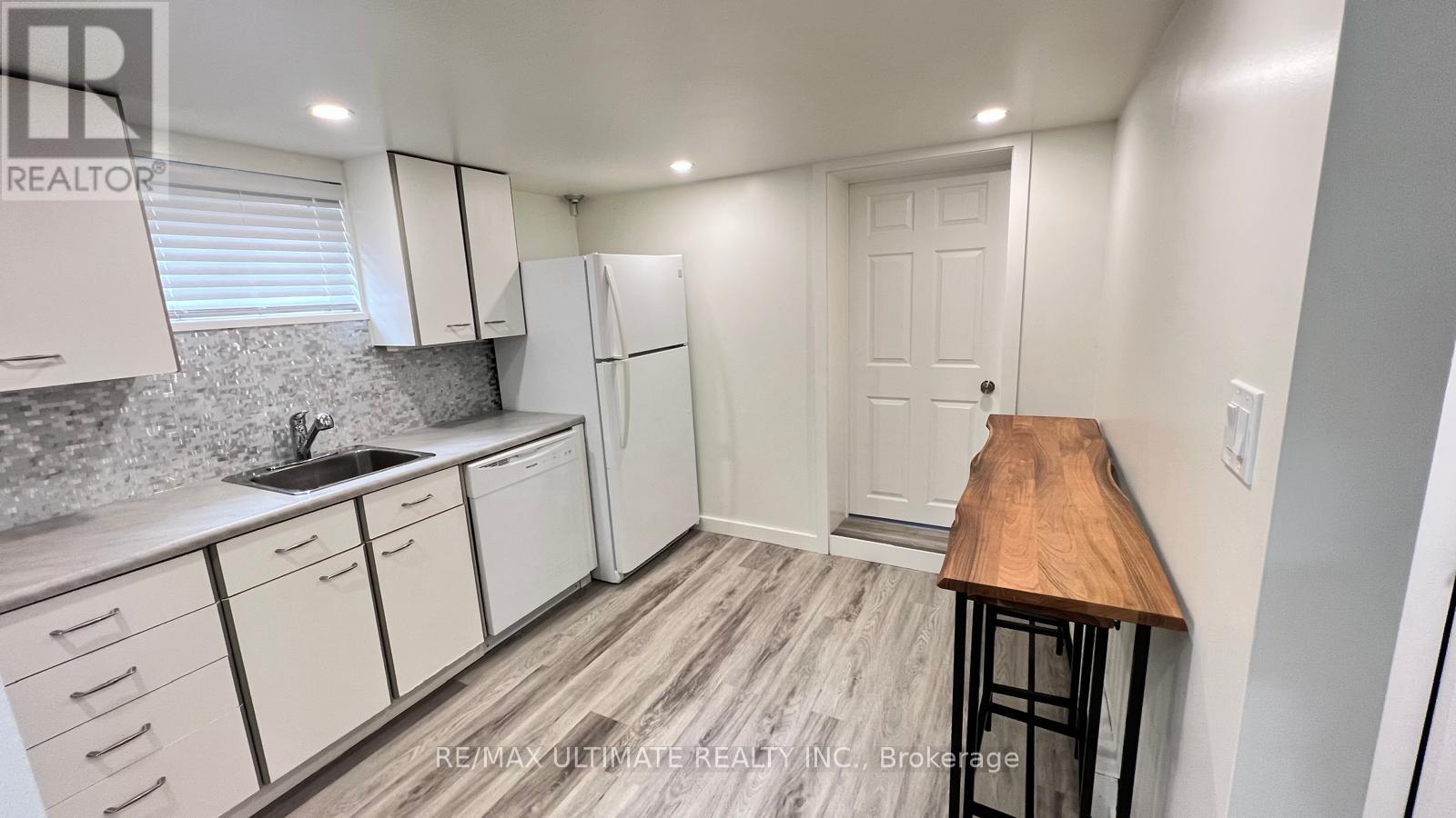 A kitchen with white cabinets and a wooden countertop.