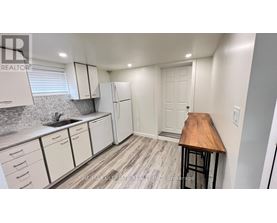 A kitchen with white cabinets and a wooden countertop.