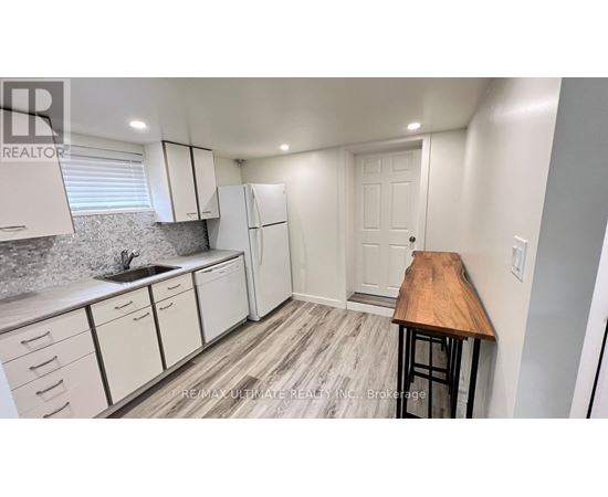 A kitchen with white cabinets and a wooden countertop.