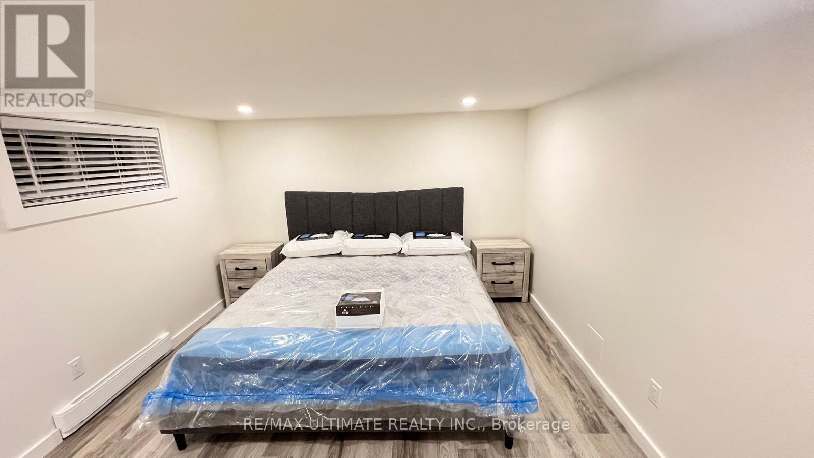 A bedroom with a bed covered in a blue sheet and a logo on the wall.