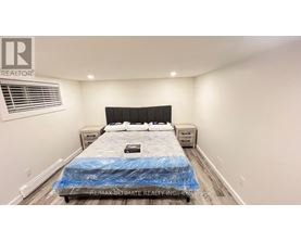 A bedroom with a bed covered in a blue sheet and a logo on the wall.