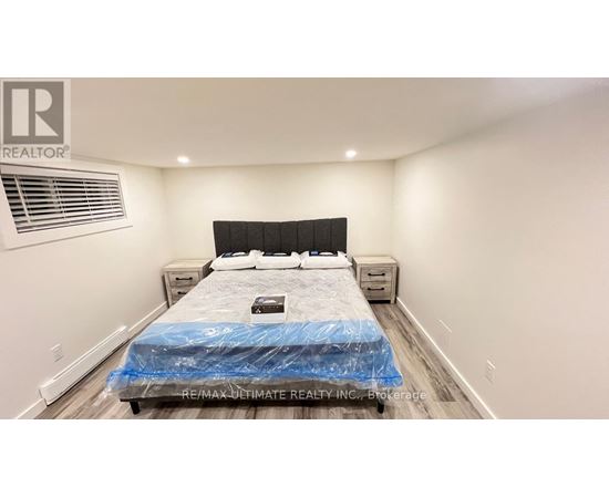 A bedroom with a bed covered in a blue sheet and a logo on the wall.