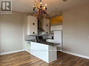 A kitchen with a white island and a chandelier.