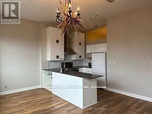 A kitchen with a white island and a chandelier.