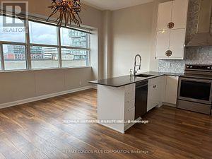 A kitchen with a large island and wooden floors.